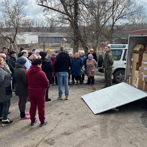 Verteilung von Hilfsgütern aus einem Anhänger in einem Dorf in der Ukraine