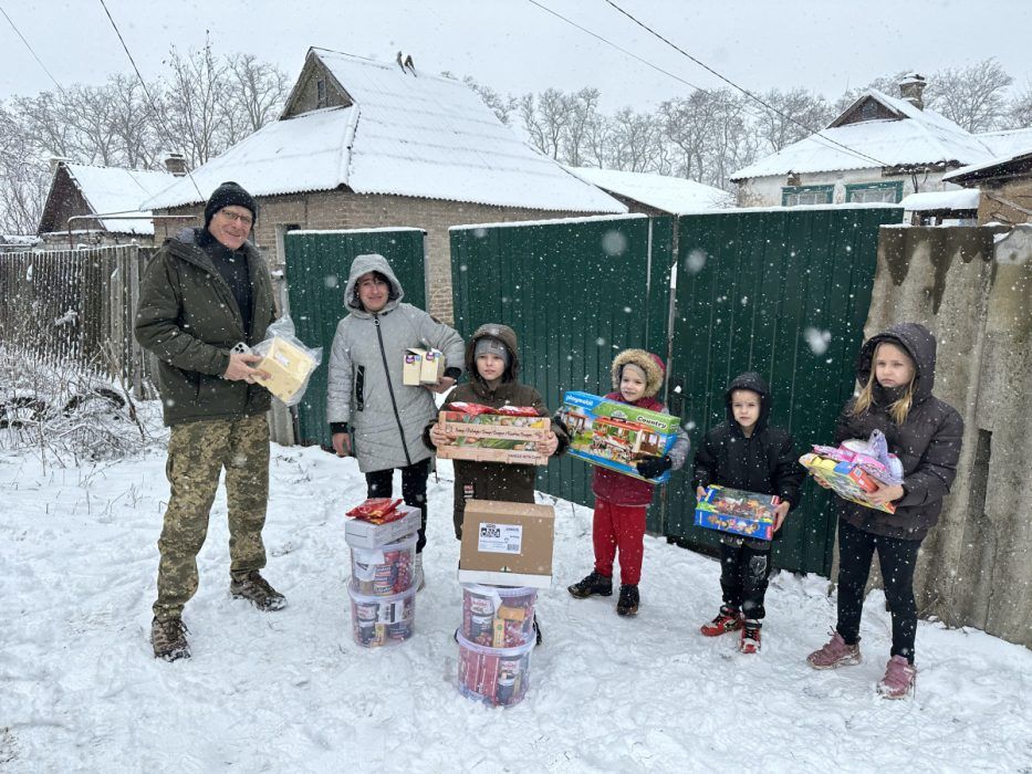 Kinder im Schnee mit Weihnachtsgeschenken