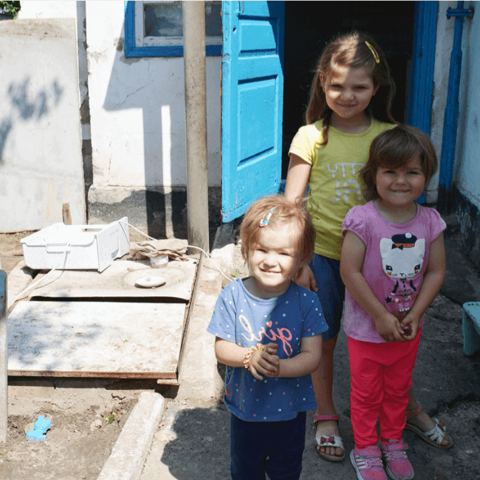Drei Mädchen vor einem Haus in der Ukraine
